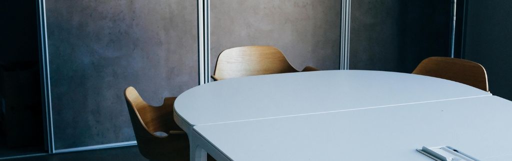 Salle de réunion moderne avec des chaises en bois et une table blanche, représentant le soutien du BOI en Thaïlande pour les entreprises internationales.