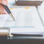 A close-up of a businessperson analyzing financial documents with charts and graphs, highlighting data related to Thai withholding tax.