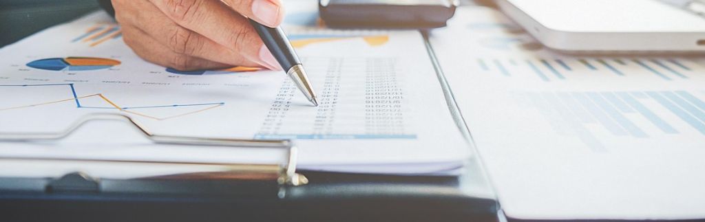 A close-up of a businessperson analyzing financial documents with charts and graphs, highlighting data related to Thai withholding tax.