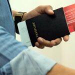 Traveler holding a passport and boarding pass, illustrating the thailand arrival digital card requirement