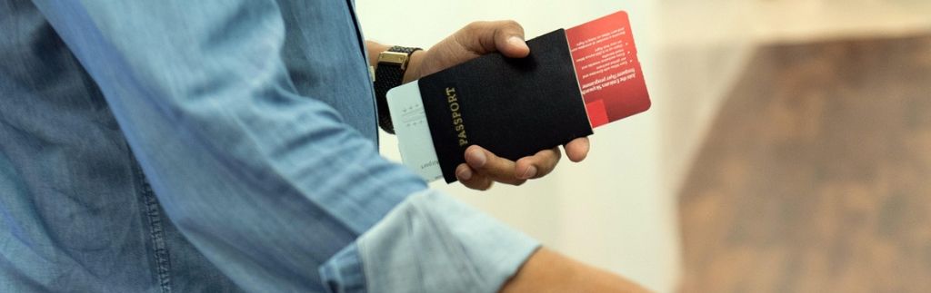 Traveler holding a passport and boarding pass, illustrating the thailand arrival digital card requirement