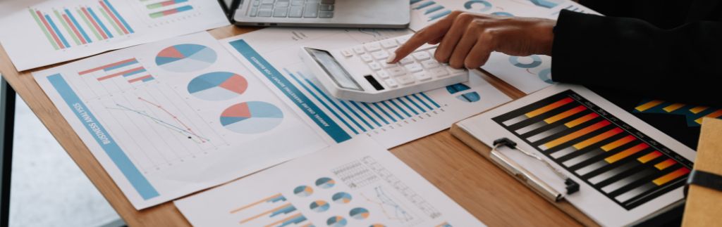 Person reviewing business charts and calculator related to Thailand tax code
