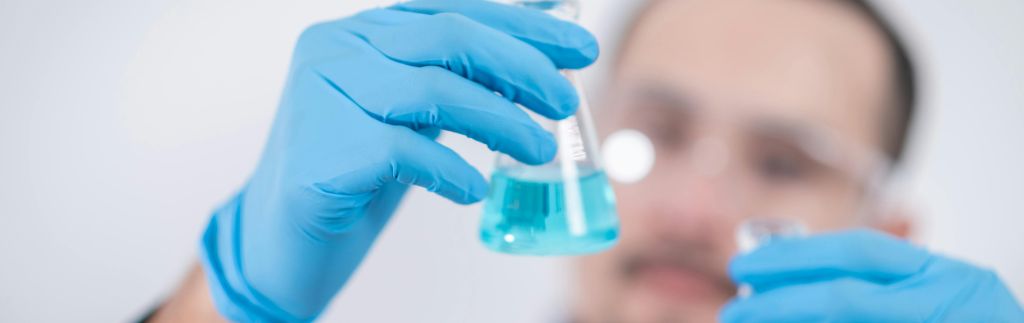 Chercheur manipulant des substances chimiques dans un laboratoire, illustrant une entreprise de biotechnologie en Thaïlande.