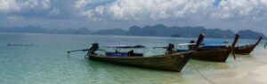 Bateaux traditionnels sur une plage de Krabi, illustrant le cadre paradisiaque pour acheter une maison à Krabi