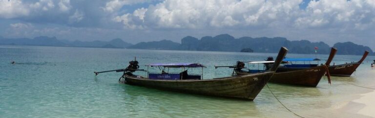 Bateaux traditionnels sur une plage de Krabi, illustrant le cadre paradisiaque pour acheter une maison à Krabi