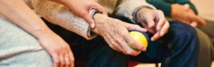 Hands of an elderly person being supported, representing retirement visa renewal Thailand.