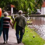 Couple de retraités marchant au bord d’un canal, illustrant le renouvellement du visa retraite Thaïlande dans un cadre paisible.