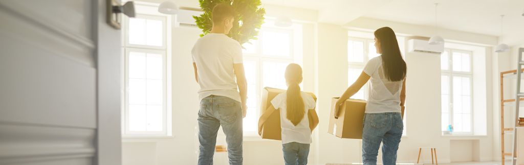 Family moving to Thailand carrying boxes into a new home