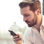 Businessman checking documents on his phone — Thailand Investment Visa