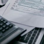 Калькулятор и налоговая декларация, символизирующие налогообложение в Таиланде