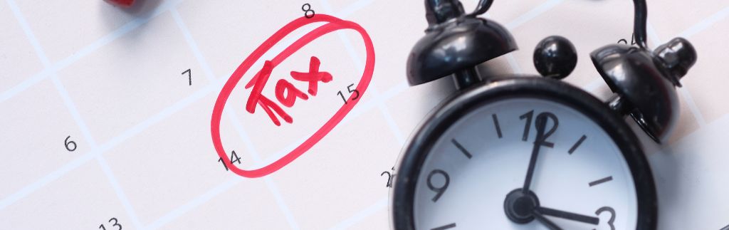 Календарь с выделенной красной ручкой датой "14" и пометкой "Tax", а также черный будильник, подчеркивающий срочность уплаты налоги в Таиланде.