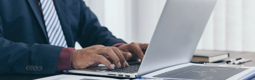 Businessman typing on laptop while preparing documents for Non Immigrant B visa in Thailand application