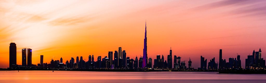 Переезд в Дубаи — панорама города на закате с видом на Бурдж-Халифу
