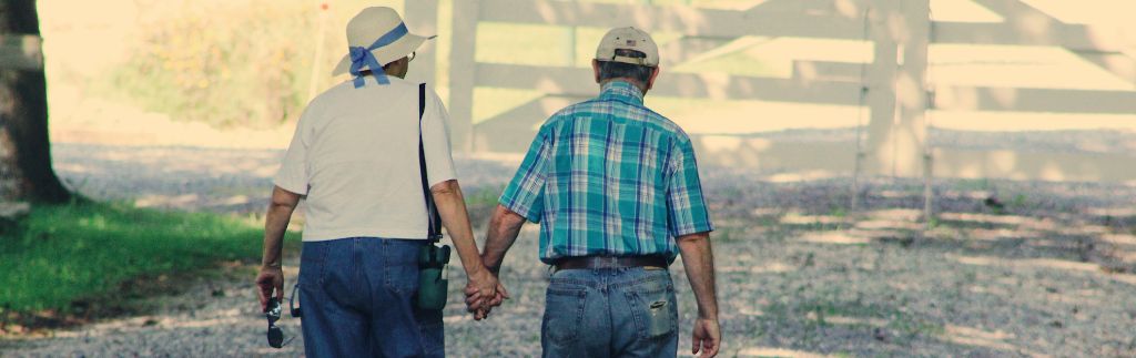 Пожилая пара гуляет в парке, символизируя преимущества пенсионной визы в Таиланде