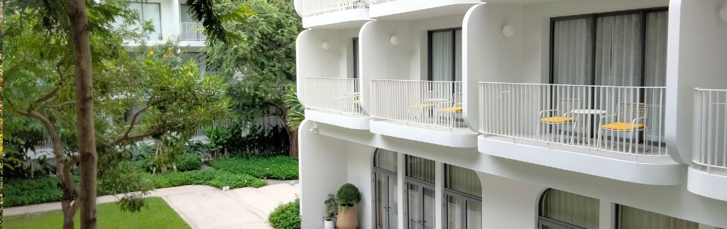 Vue sur les balcons modernes d’un immeuble résidentiel avec jardin, idéal pour acheter appartement à Chiang Mai.