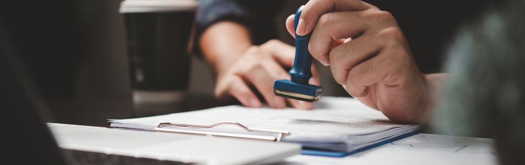 Person reviewing and stamping official company documents related to certificate of incorporation Thailand
