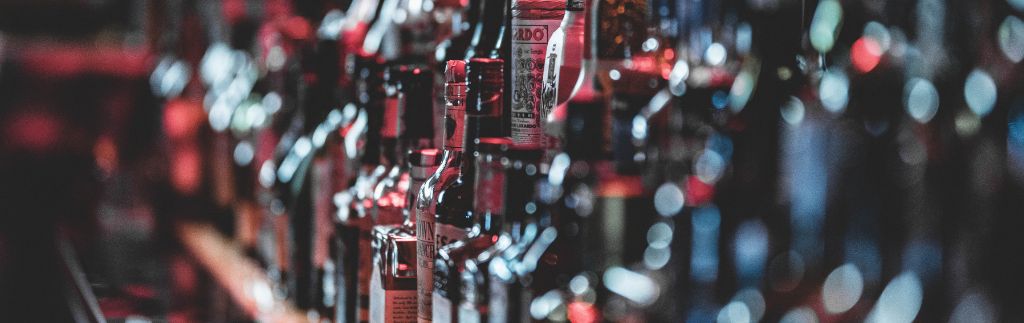 Row of liquor bottles in a bar illustrating thailand drinking age regulations