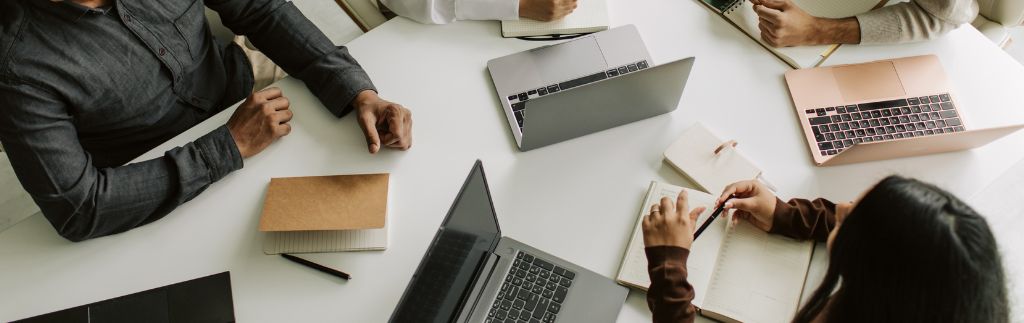 Group of professionals in a meeting with laptops and notebooks, representing teamwork and opportunities to work in Thailand