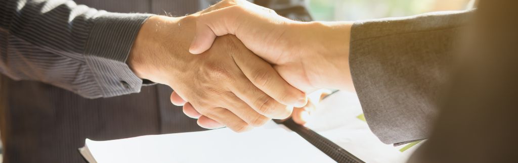 Handshake after signing a share purchase agreement in Thailand between foreign investor and Thai company