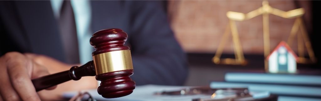 Giudice con martelletto e bilancia della giustizia, simbolo della legge sugli alcolici in Thailandia.