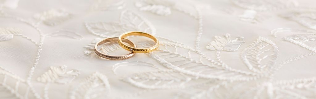 Fedi nuziali su un tessuto ricamato, simbolo dell’unione e delle tradizioni legate al matrimonio thailandese.