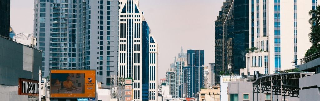 Panoramica urbana di Bangkok con grattacieli moderni e traffico cittadino, simbolo della vita quotidiana nella capitale thailandese.