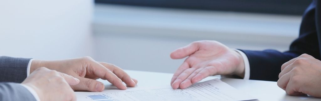 Zwei Geschäftsleute besprechen ein Steuerdokument, das das Konzept eines Doppelbesteuerungsabkommens zwischen Thailand und anderen Ländern darstellt.