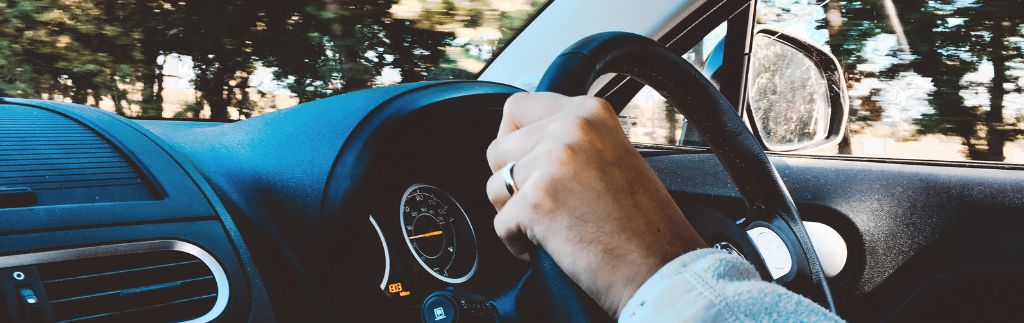 Persona alla guida di un’auto, simbolo della necessità di una patente di guida internazionale in Thailandia per i conducenti stranieri.