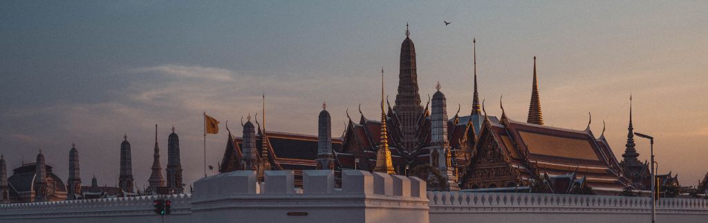 Sunset view of the Grand Palace in Bangkok, Thailand, symbolizing the blend of tradition and innovation represented by TouristDigiPay.