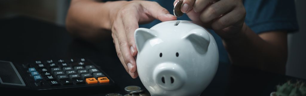 Jemand öffnet ein Sparschwein, was den Prozess symbolisiert, ein Bankkonto in Thailand eröffnen zu können.