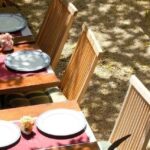 Открыть ресторан в Таиланде — уютная открытая терраса с сервированными столами и деревянной мебелью