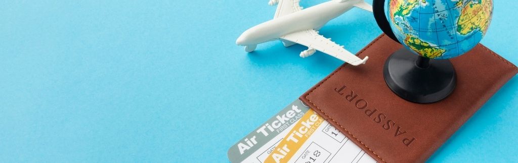 Image représentant un passeport, un billet d’avion et un globe, illustrant la pratique du visa run en Thaïlande.