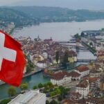 Vue de la Suisse avec drapeau national illustrant les démarches de visa pour Suisse en Thaïlande