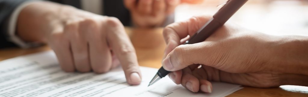 Two people signing a legal document related to foreigners working in Thailand.