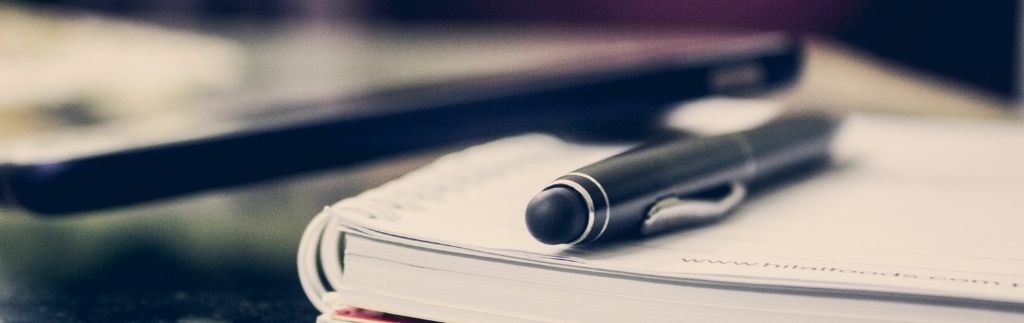 Pen and TM30 Thailand form on a desk, symbolizing immigration reporting procedures.
