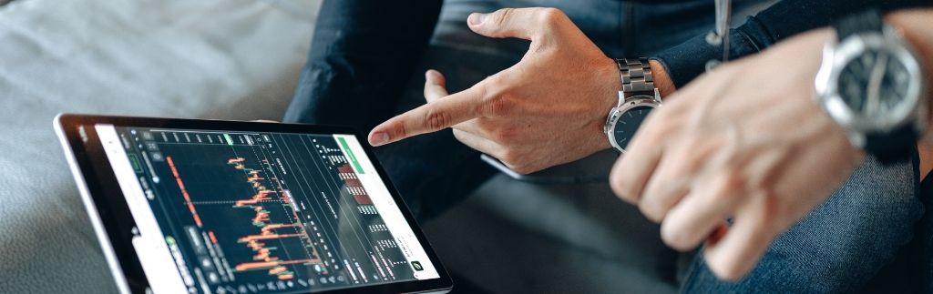 Zwei digitale Nomaden besprechen Finanzdaten auf einem Tablet – Symbol für ortsunabhängiges Arbeiten mit dem Nomadenvisum Thailand 2025.