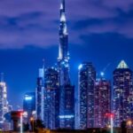 Skyline notturno di Dubai con i grattacieli illuminati.