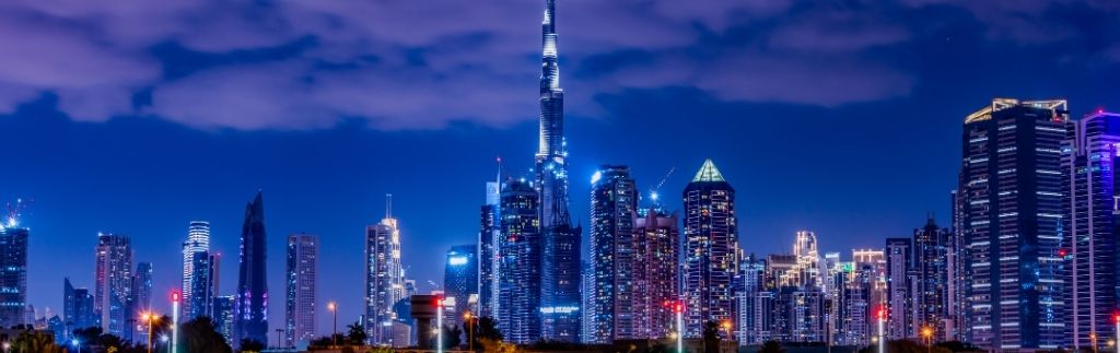 Skyline notturno di Dubai con i grattacieli illuminati.