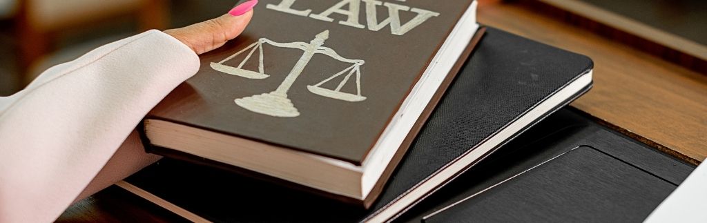 Книги по праву и символ справедливости на столе, иллюстрирующие юридические аспекты, включая запрет на продажу алкоголя в Таиланде.