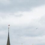 Vue sur un bâtiment en Suisse avec un drapeau suisse flottant, symbolisant la retraite en Thaïlande pour un Suisse.