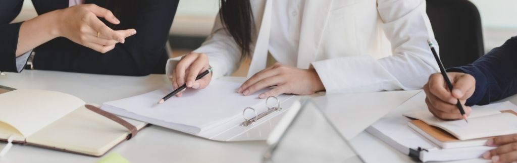 Professionals discussing BOI tax incentives and reviewing business documents.