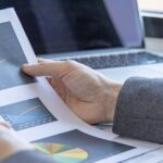 Business person analyzing graphs and charts related to business in Koh Samui.