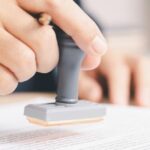 Un notaire public en Thaïlande apposant son sceau sur un document légal.