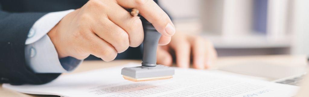 Un notaire public en Thaïlande apposant son sceau sur un document légal.