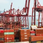 A bustling port with shipping containers and cranes, representing Thailand's customs free zones for international trade.