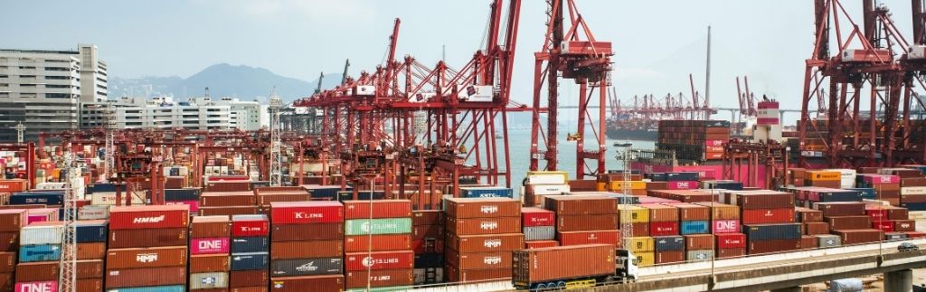 A bustling port with shipping containers and cranes, representing Thailand's customs free zones for international trade.