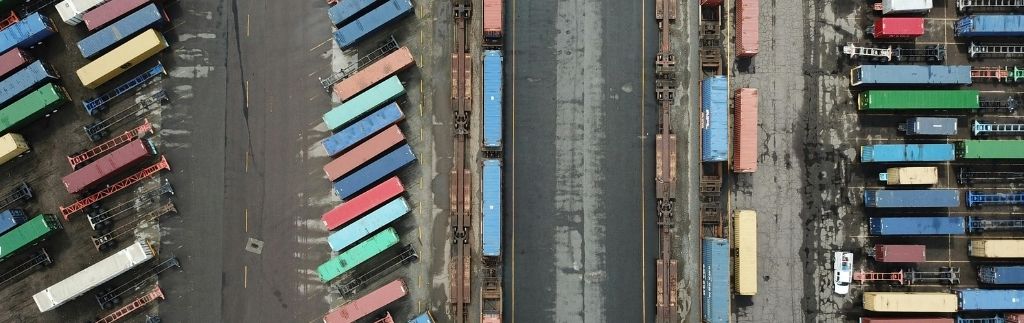 Vue aérienne des conteneurs colorés dans une Zone franche douanière en Thaïlande, représentant un centre de transport et de logistique.