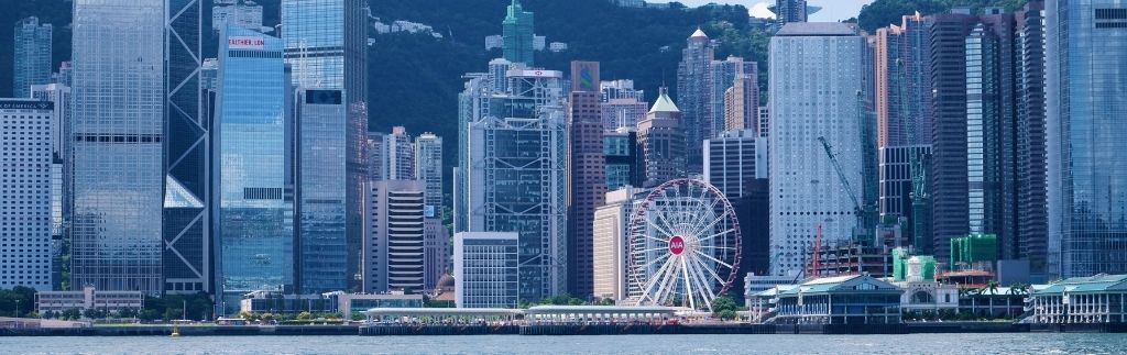 Hong Kong skyline with skyscrapers and a ferris wheel, representing a favorable investment environment due to tax exemption Hong Kong.