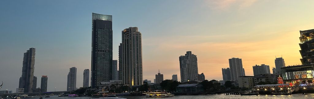 Bangkok skyline at sunset with Chao Phraya River and modern skyscrapers