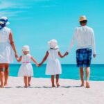 Familien in Thailand genießen einen Tag am Strand unter tropischem Himmel